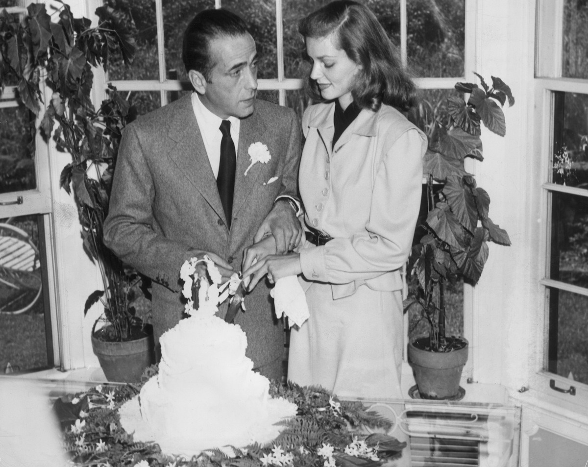 21st May 1945: Married American actors Lauren Bacall and Humphrey Bogart (1899 - 1957) cut the cake at their wedding. (Photo by Hulton Archive/Getty Images) classifilm.com همفری بوگارت لورن باکال نامه های عاشقانه